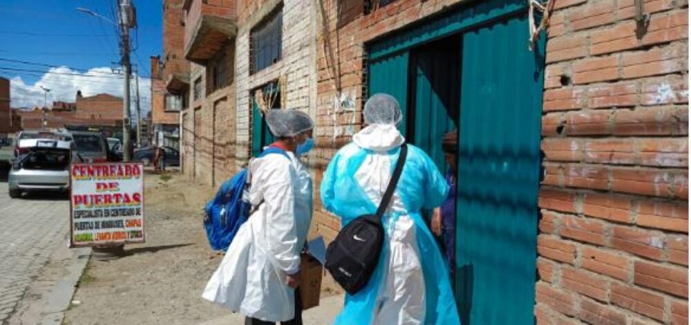 Un equipo de salud en la puerta de una vivienda en El Alto. Foto: Gobierno Municipal de El Alto. 