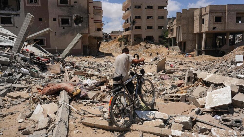 Un hombre empuja su bicicleta sobre los escombros en el sector de Bani Suhayla, en Jan Yunis, sur de Gaza. (Foto de archivo: 30.07.2024)