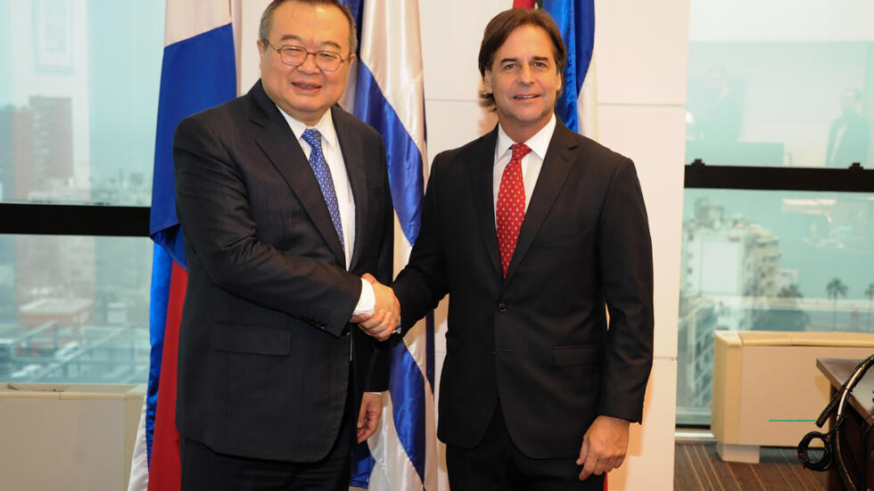 El presidente uruguayo Luis Lacalle Pou (D) saluda al jefe del Departamento Internacional del Partido Comunista Chino, Liu Jianchao, en Montevideo el 6 de agosto de 2024.