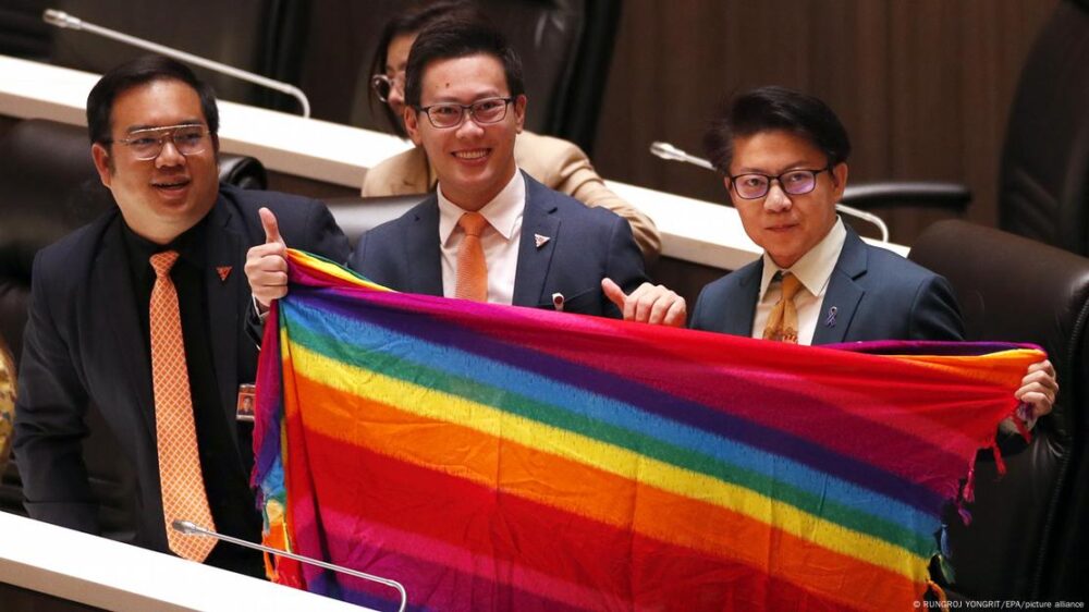 Líderes del partido tailandés Avanzar con una bandera con los colores del arcoíris como apoyo a la comunidad LGBTQIA.