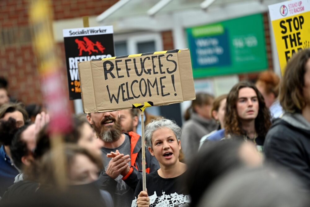 Una manifestante muestra una pancarta con la frase "Refugiados bienvenidos" en una concentración antirracista en Oxford, en el oeste de Inglaterra, el 7 de agosto de 2024