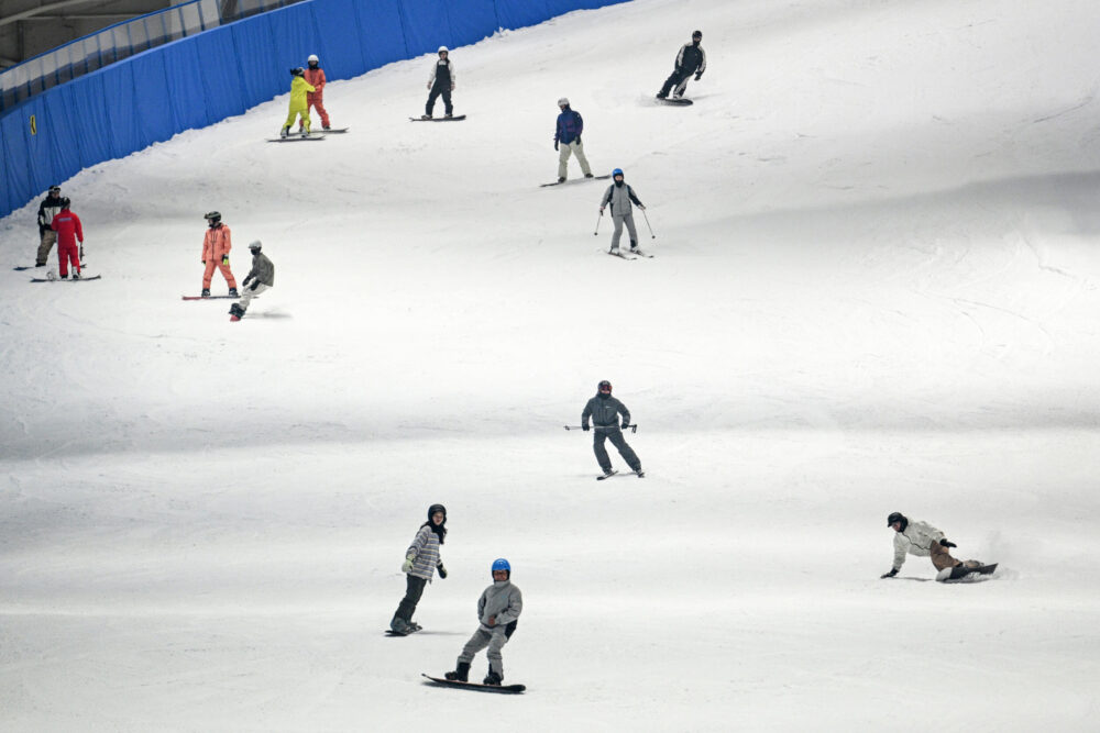 Aficionados al snowboard en la pista cubierta de esquí L*SNOW Indoor Skiing Theme Resort, la mayor del mundo, el 6 de septiembre de 2024