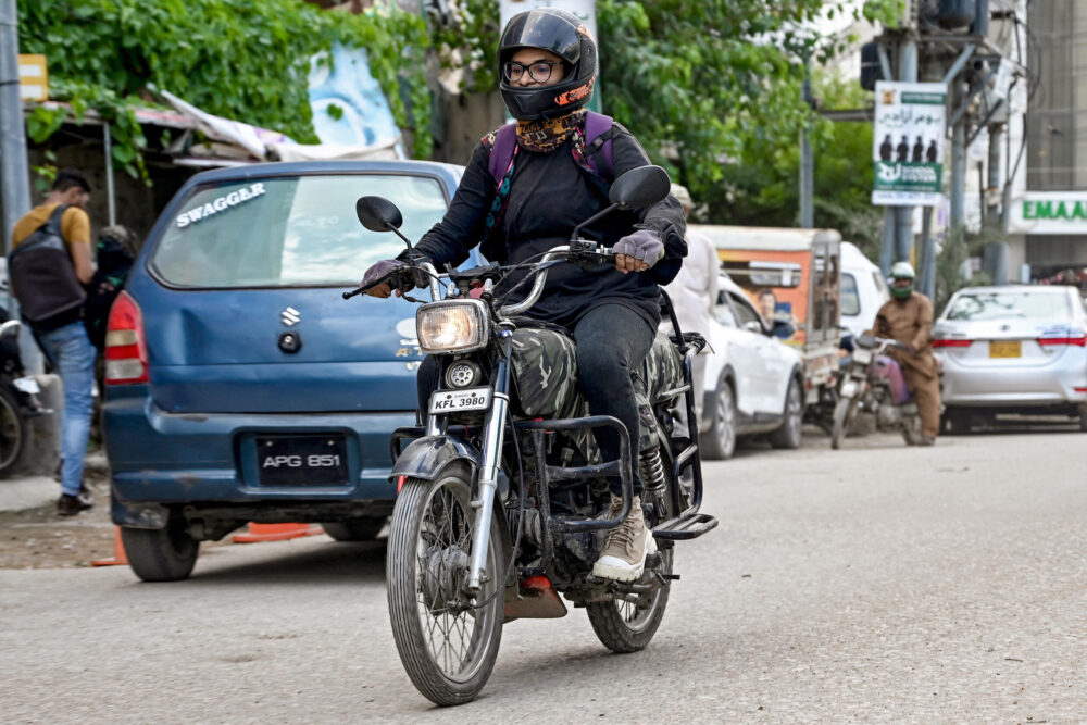 Amina Sohail conduce su motocicleta en las calles de Karachi, en Pakistán, el 19 de agosto de 2024