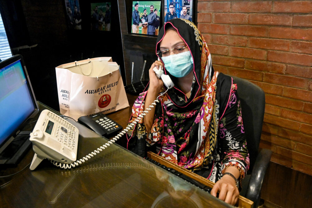 Hina Saleem atienda una llamada telefónica en la fábrica donde trabaja como operadora en Korangi, la mayor área industrial de la ciudad pakistaní de Karachi, el 17 de agosto de 2024