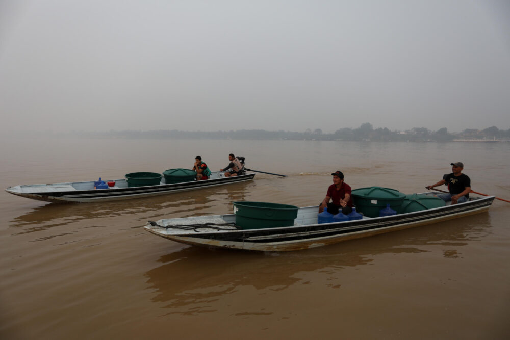 Un grupo de personas transporta agua potable en botes en el río Madeira, en Humaita, Brasil, el 7 de septiembre de 2024.