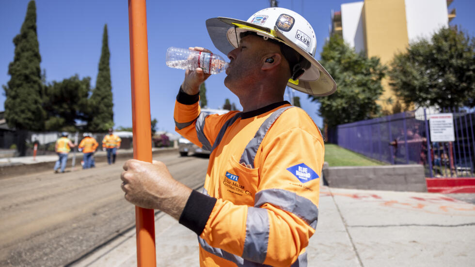 Un trabajador bebe agua para combatir el calor en las obras de una carretera en Los Ángeles el 4 de septiembre de 2024