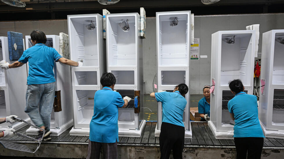 Varios empleados trabajan en la cadena de montaje de refrigeradores de una fábrica de electrodomésticos de Suqian, al este de China, el 11 de septiembre de 2024