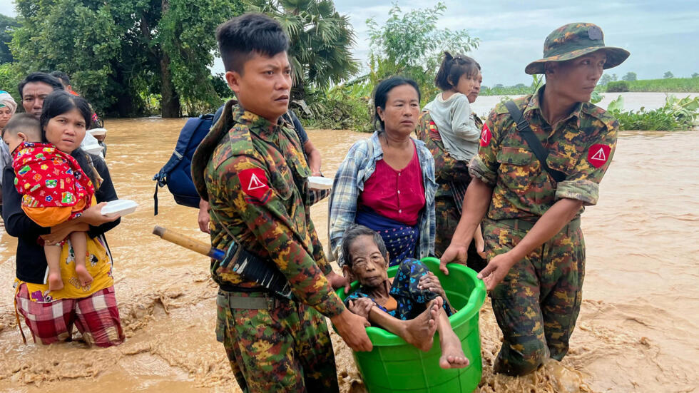 Militares ayudan a los habitantes a cruzar las aguas en Pyinmana, en la región de Naypyidaw en Birmania, el 13 de septiembre de 2024, tras las fuertes lluvias provocadas por el tifón Yagi