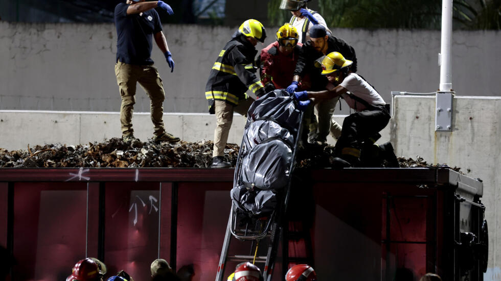 Un grupo de bomberos, junto a peritos forenses y miembros de la fiscalía, recuperan uno de los tres cuerpos atados dentro de los vagones de un tren que cruza Guadalajara, estado de Jalisco, México, el 17 de septiembre de 2024.