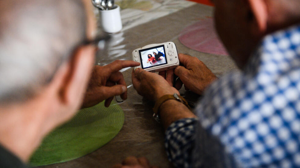 Un paciente con alzheimer (izq.) participa en un taller de fotografía el 9 de mayo de 2023 en una residencia en Arles, en el sureste de Francia