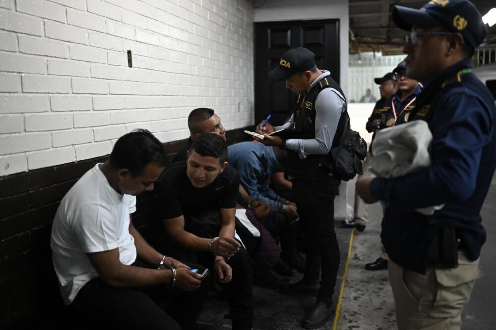 Miembros de la Inspección General de la Policía Nacional Civil Dde Guatemala vigilan a agentes detenidos en Ciudad de Guatemala el 1 de octubre de 2024