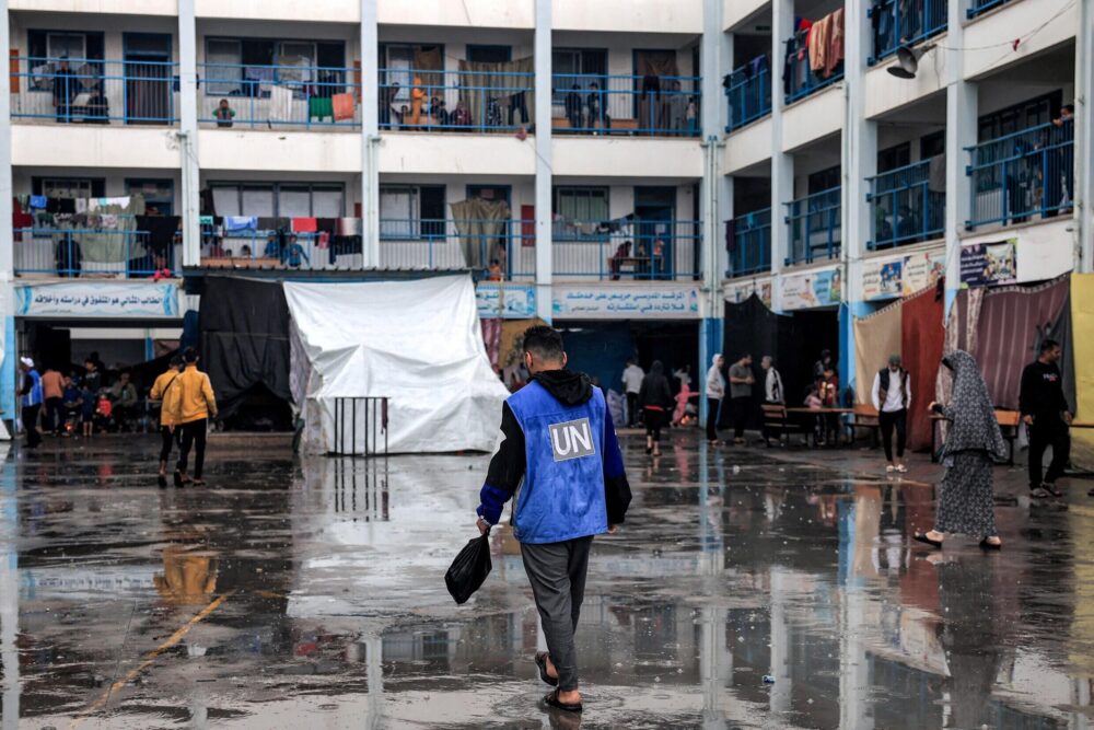 Una persona con un chaleco de la Agencia de la ONU para los Refugiados Palestinos (UNRWA) camina por el patio de una de sus escuelas en Rafah, en el sur de la Franja de Gaza, donde se refugian desplazados internos, el 14 de noviembre de 2023