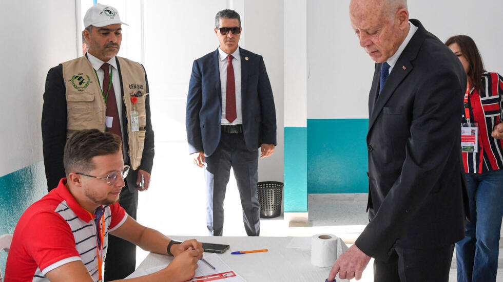 El presidente tunecino Kaïs Saïed moja su dedo en tinta tras depositar su voto en un colegio electoral durante las elecciones presidenciales de 2024 en Túnez, el 6 de octubre de 2024.