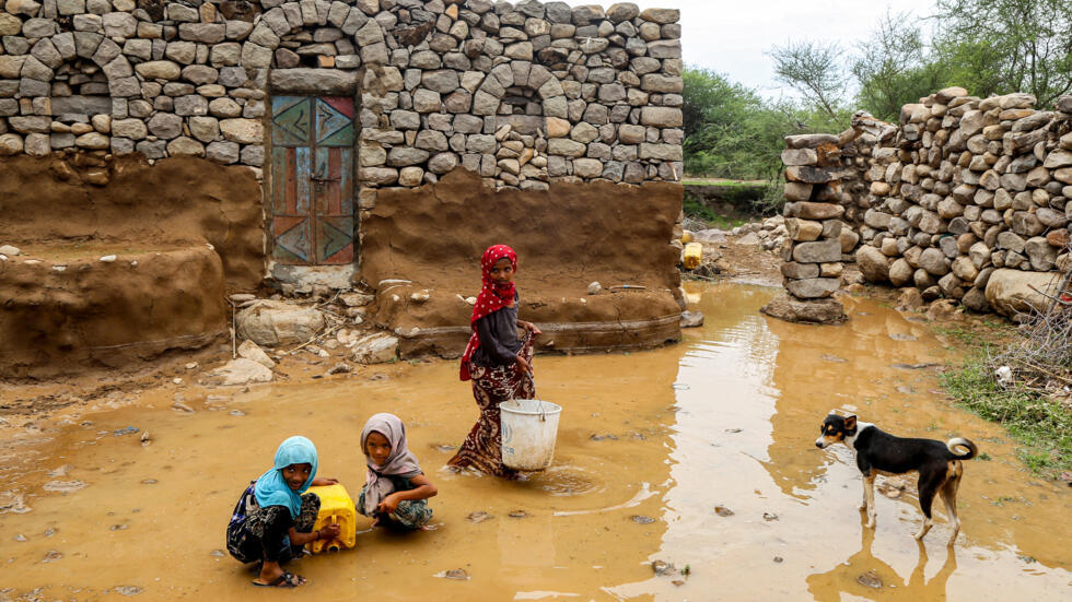 Unas niñas llenan unos bidones con el agua de los charcos dejados por unas inundaciones en la región de Hays, en Yemen, el 28 de agosto de 2024