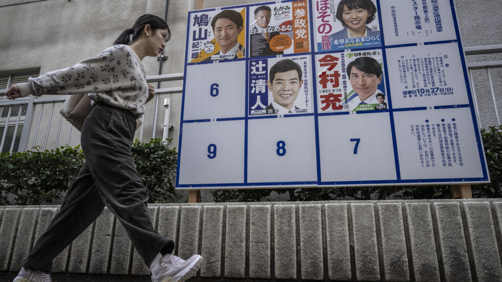 A woman walks past campaign Una mujer pasa por delante de unos carteles electorales para los comicios a la Cámara de Representantes de Japón, el 15 de octubre de 2024 en Tokio