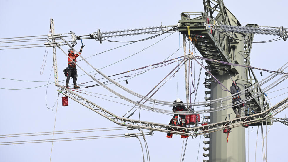 Unos técnicos de un operador de transmisión de electricidad trabajan en una torre de alto voltaje en Pforzheim, en el sur de Alemania, el 16 de octubre de 2024