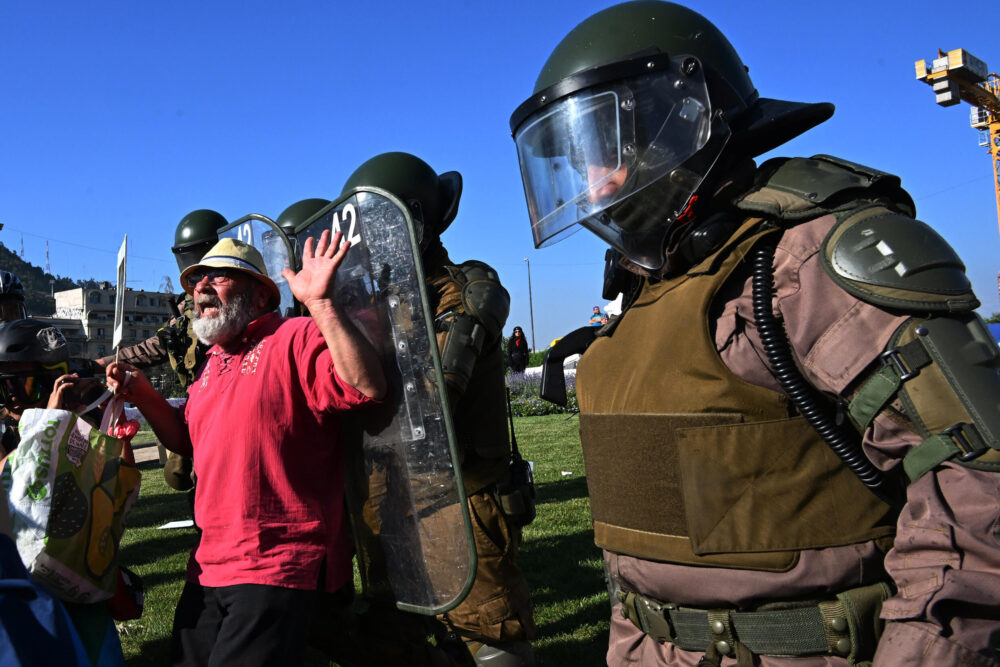 Policías y manifestantes son fotografiados en el quinto aniversario de el "Estallido Social" en Chile, en Santiago, el 18 de octubre de 2024