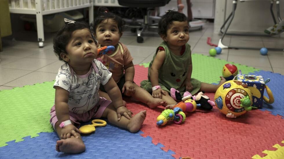 Las trillizas palestinas Najwa, Najma y Nour juegan en una sala para niños del Hospital Al Makassed en Jerusalén Este el 31 de julio de 2024.