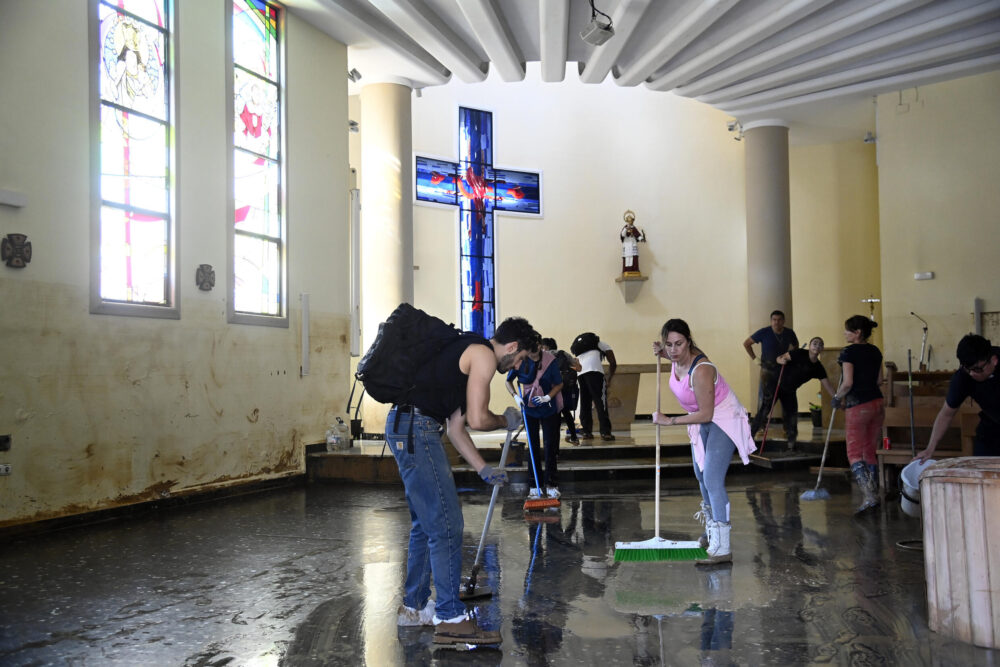 Voluntarios y vecinos limpian el barro de la iglesia de la localidad de Paiporta el 1 de noviembre de 2024, tras las devastadoras inundaciones que azotaron la región de Valencia, en el este de España