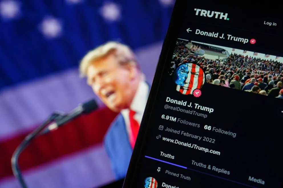 Trump con una imagen de su perfil en la red X en un celular. Foto: EFE