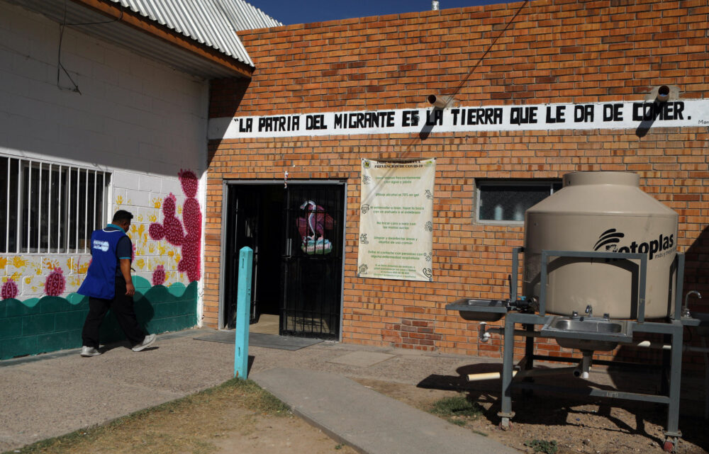 Un migrante entra caminando al refugio Casa del Migrante en Ciudad Juárez, estado de Chihuahua, México, el 6 de noviembre. "La patria del migrante es la tierra que le da de comer", lee un cartel pintado en la pared de entrada del refugio