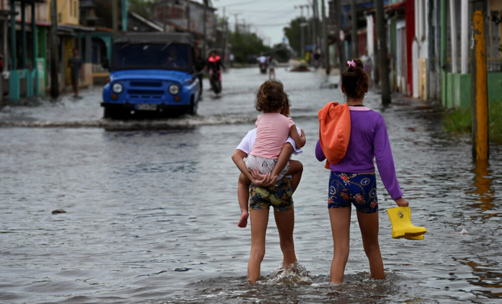 Niños caminan por inundadas calles después del paso del huracán Rafael en Batabano, provincia de Artemisa, Cuba, el 7 de noviembre de 2024. La provincia sigue sin electricidad.