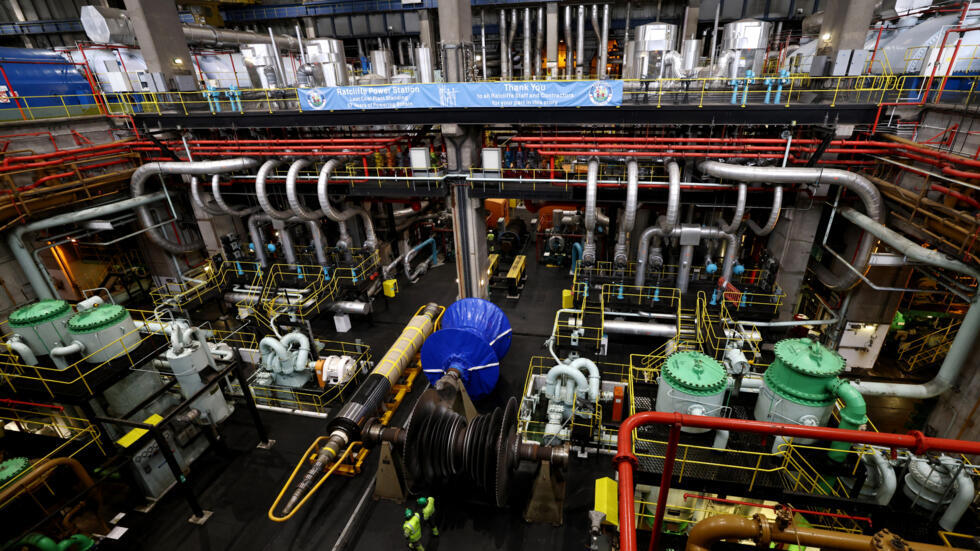 Unos trabajadores caminan por la sala de turbinas desconectadas de la planta de carbón de Nottinghamshire, en el centro de Inglaterra, el 1 de octubre de 2024