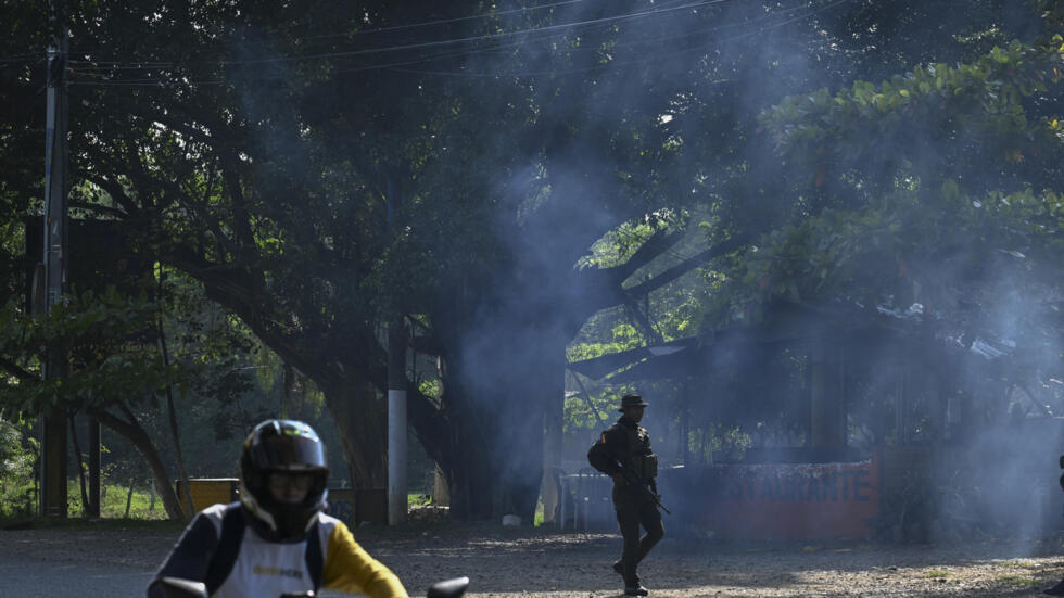 Un policía monta guardia en un puesto de control en Jamundi, Colombia, el 17 de octubre de 2024, tras una explosión cerca de una comisaría atribuida a disidentes de la guerrilla de las FARC