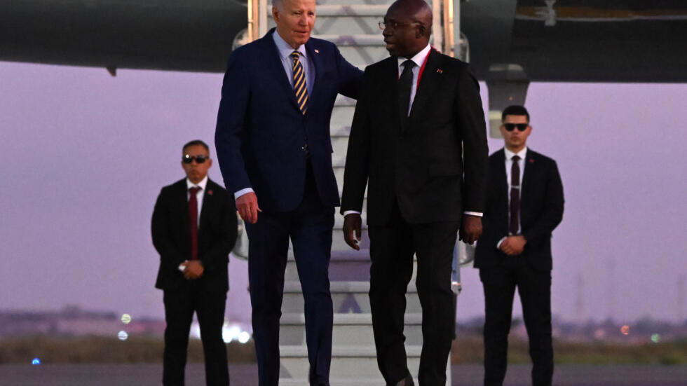 El presidente Joe Biden (izq) charla con el ministro de Exteriores angoleño, Tete Antonio, tras aterrizar en el aeropuerto internacional de Luanda, el 2 de diciembre de 2024