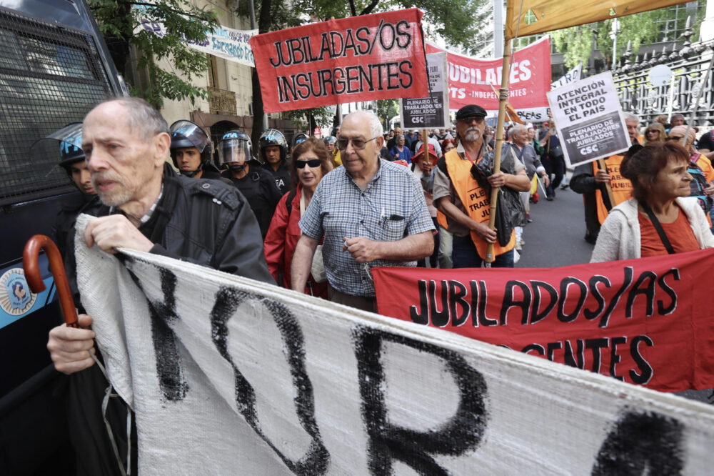 Ruben Cocorullo, en el centro, lleva un cartel de su agrupación "Jubilados insurgentes" en una protesta frente al Congreso en Buenos Aires