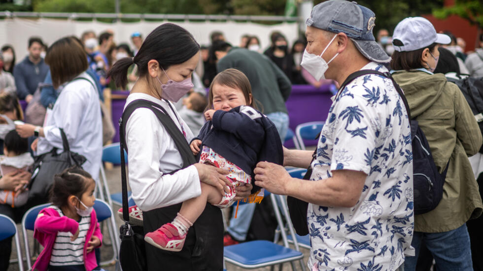 Unos padres y su hija, fotografiados en Tokio el 22 de abril de 2023