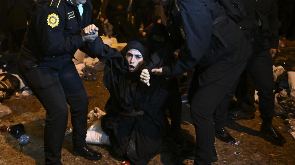 Policías forcejean con una mujer tras recuperar a niños que miembros de la secta judía Lev Tahor, investigada por supuestos abusos a menores, sustrajeron de un albergue estatal, en la ciudad de Guatemala el 23 de diciembre de 2024.