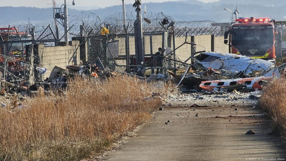 Los restos calcinados de la aeronave yacen junto a un muro al final de la pista en el aeropuerto de Muan.