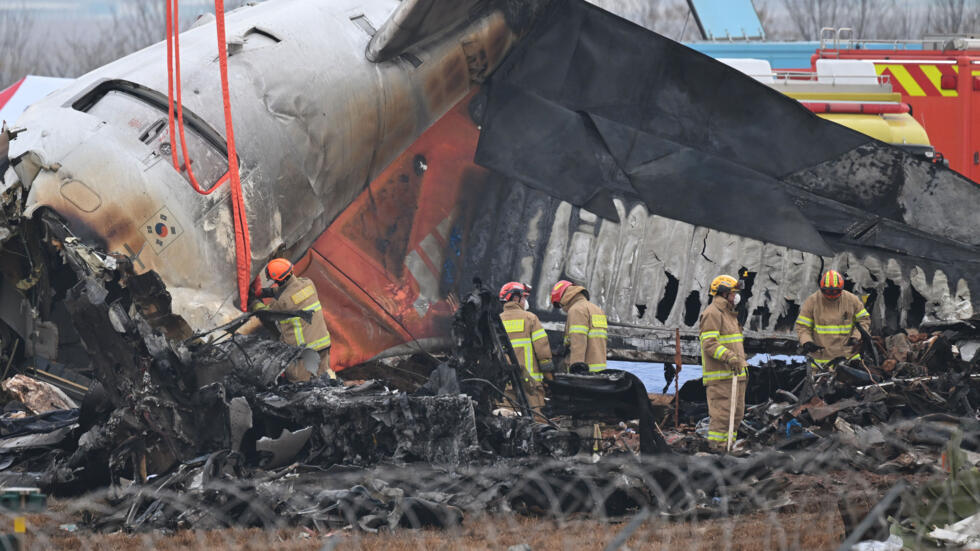 Bomberos y equipos de rescate trabajan entre los restos del avión Boeing 737 de la compañía de Jeju Air siniestrado en el aeropuerto de Muan, el 30 de diciembre de 2024 en esa ciudad al suroeste de Corea del Sur