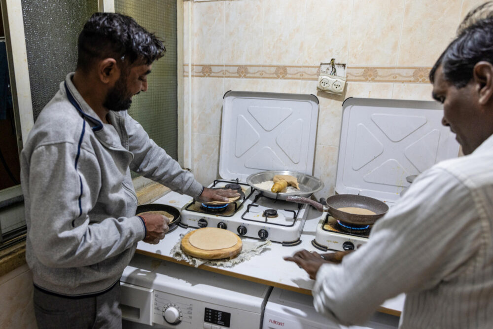 Ciudadanos indios que trabajan en el sector de la construcción preparan una comida en su piso en Tel Aviv, el 23 de diciembre de 2024 en Israel