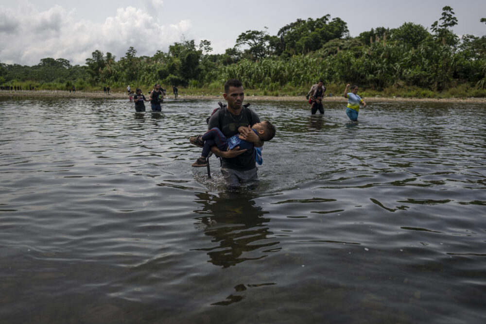 (FILES) Migrantes cruzan el río Tuquesa cerca de Bajo Chiquito, el primer puesto de control migratorio tras pasar la selva panameña del Darién, Panamá, el 22 de septiembre de 2023