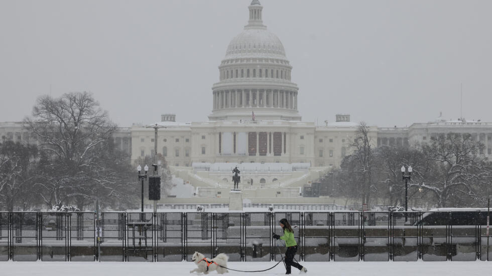 Una mujer pasea a su perro cerca del Capitolio de Estados Unidos mientras cae nieve durante una tormenta invernal, en Washington, el 6 de enero de 2025