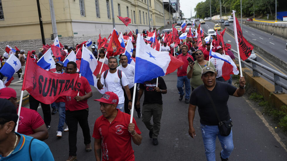 Manifestantes ondean banderas panameñas en una marcha convocada por sindicatos de izquierda en el día de los estudiantes "mártires" en la Ciudad de Panamá, el 9 de enero de 2025.