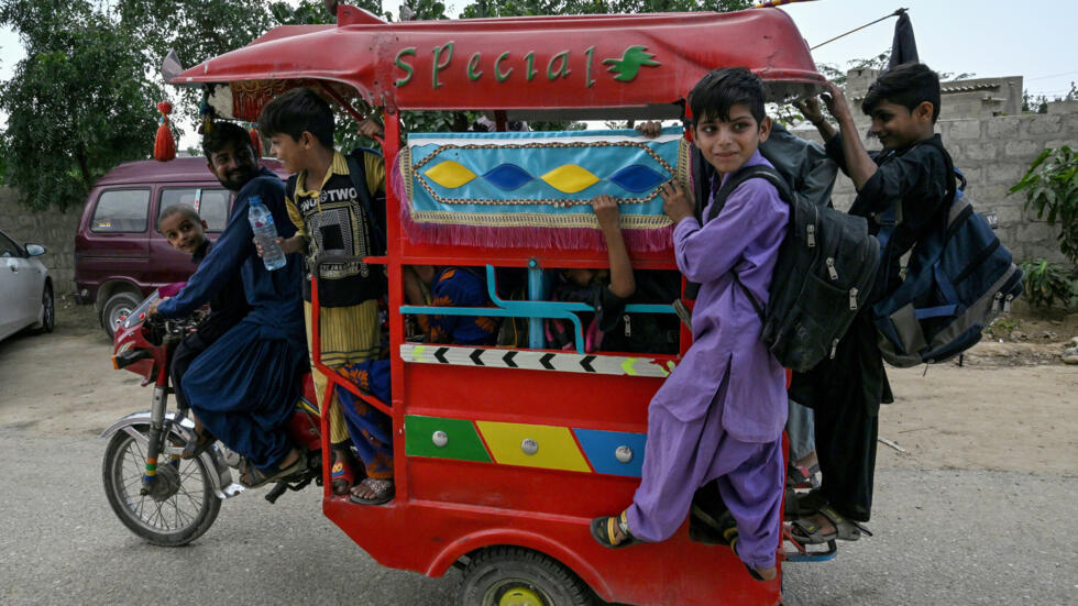 Unos niños circulan en "rickshaw" a la salida de la escuela en el pueblo de Abdullah Goth, en las afueras de Karachi, en el sur de Pakistán, el 13 de noviembre de 2024