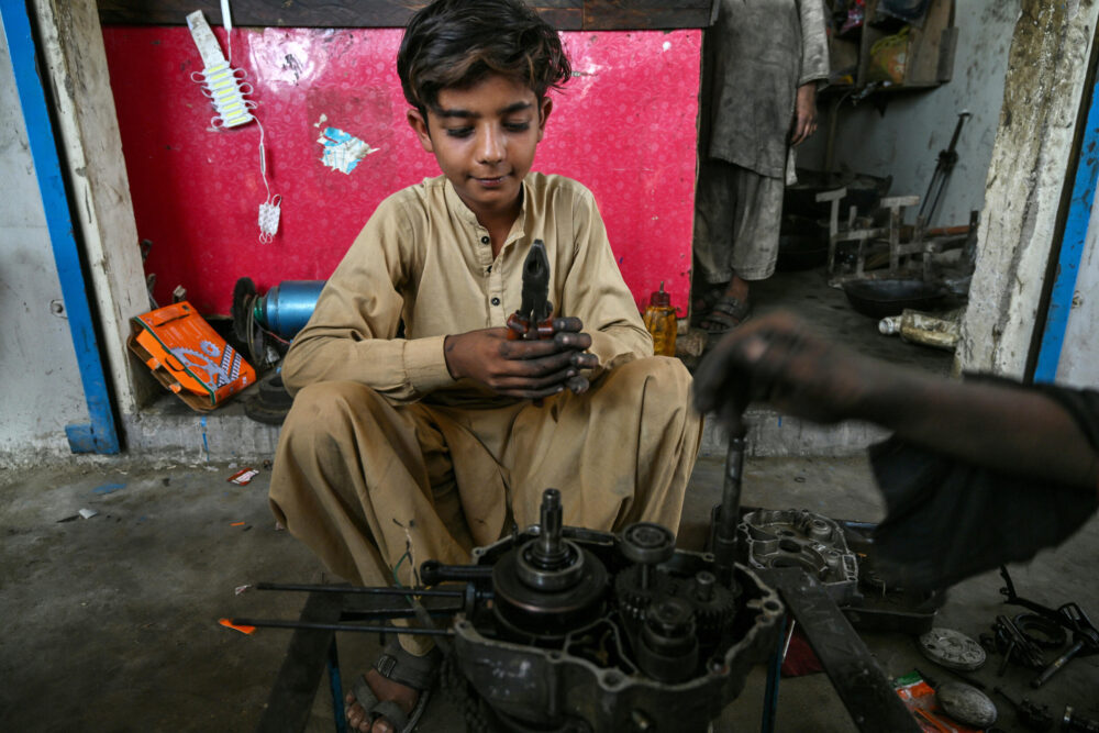 Kamran Imran, un niño de 10 años, trabaja por las tardes en taller de mecánica en Abdullah Goth, en la periferia de Karachi, en el sur de Pakistán, el 13 de noviembre de 2024