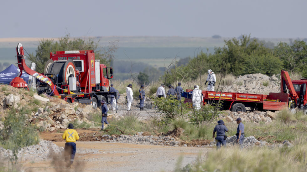 Los socorristas y la policía portan unos cadáveres rescatados en una mina de oro abandonada en Stilfontein, Sudáfrica, el 13 de enero de 2025