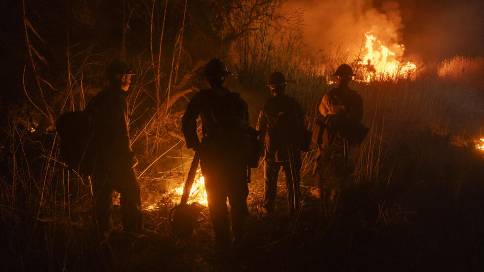 Bomberos ayudan a controlar la propagación del incendio de un automóvil en Oxnard, al noroeste de Los Ángeles, California, el 13 de enero de 2025