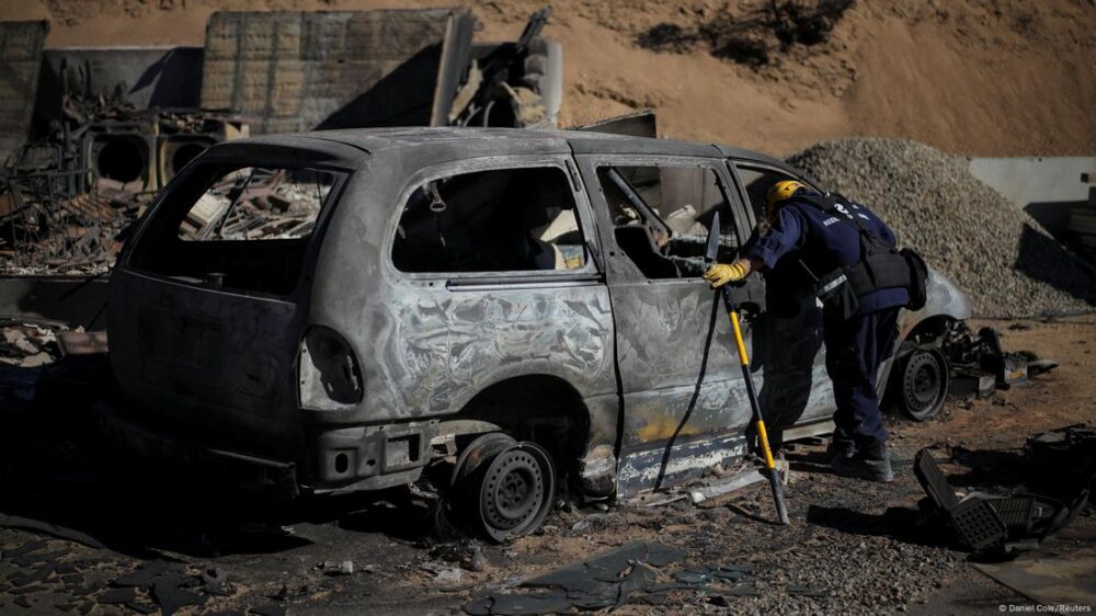 Un rescatista inspecciona los restos de un vehículo calcinado por el incendio Eaton, en Altadena. Las autoridades temen encontrar más víctimas entre los escombros.