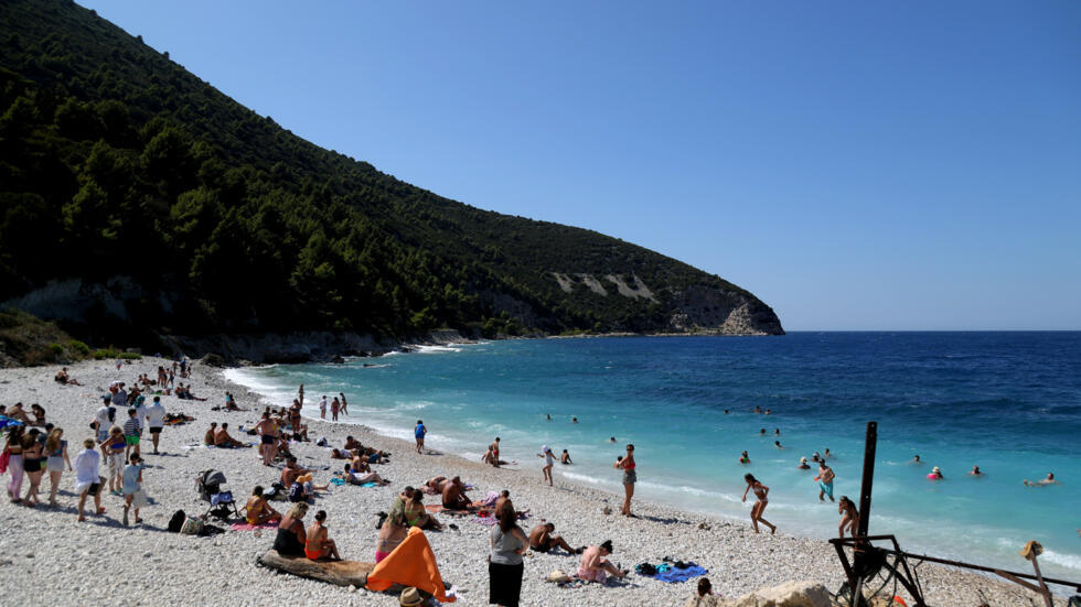 Los turistas disfrutan de un día de playa en la isla mediterránea de Sazan, cerca de la ciudad de Vlore (Albania), el 30 de julio de 2024