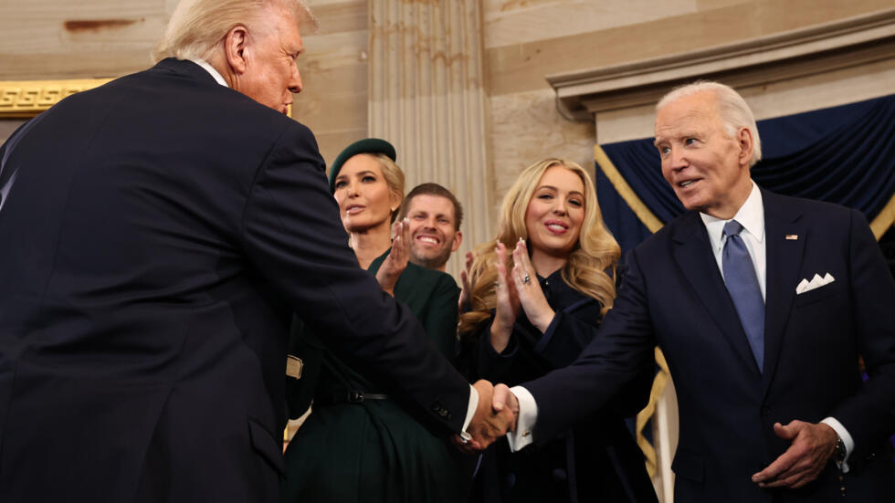 El nuevo presidente de Estados Unidos, Donald Trump, y el expresidente Joe Biden se dan un apretón de manos durante la ceremonia de investidura del republicano, el 20 de enero de 2025 en el Capitolio en Washington