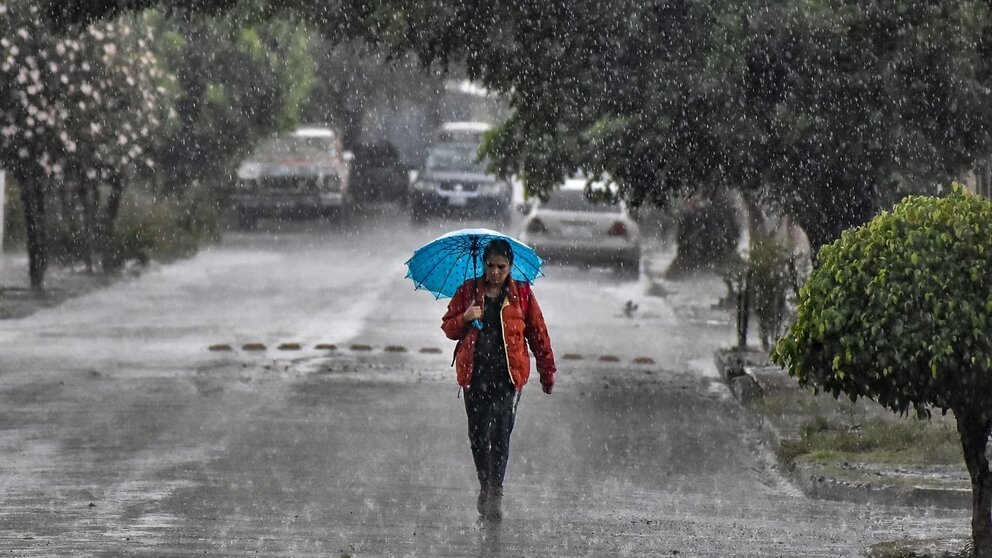 Una mujer se protege de la lluvia con un paraguas. CRÉDITO: ARCHIVO