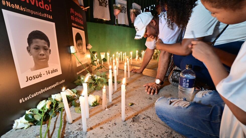 En Guayaquil, Luis Arroyo (C) llora el 8 de enero de 2025 junto a los retratos de sus hijos Ismael (15 años) y Josué (14), hallados muertos junto a dos amigos de 11 y 15 años, tras ser detenidos por militares ecuatorianos