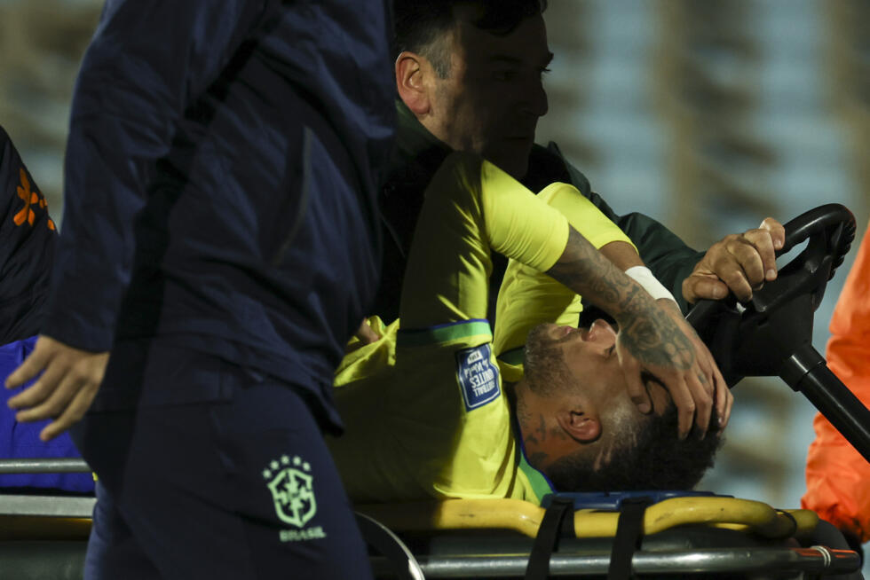 El delantero brasileño Neymar deja el campo llorando tras lesionarse gravemente la rodilla izquierda durante el partido entre Brasil y Uruguay, por las eliminatorias sudamericanas para el Mundial de 2026, en el estadio Centenario de Montevideo el 17 de octubre de 2023.