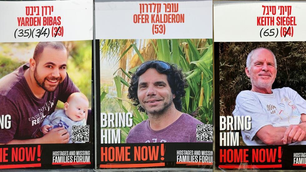 Carteles de los tres rehenes israelíes liberados por Hamás este sábado en la Franja de Gaza, de izquierda a derecha: Yarden Bibas, Ofer Kalderon y Keith Siegel