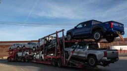 Un camión cargado de camionetas avanza para cruzar a Estados Unidos junto al muro fronterizo en el puerto comercial de Otay en Tijuana, estado de Baja California, México, el 26 de noviembre de 2024.